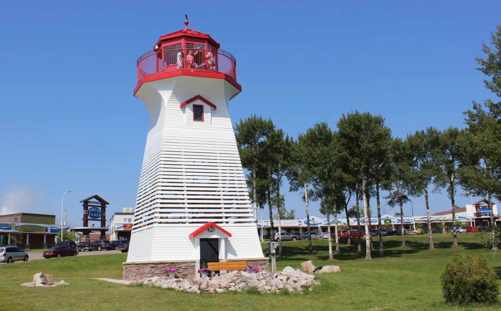 phare blanc et rouge dans paysage vert