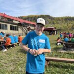 Un jeune élève appartenant à l'équipe des bleus avec son bout de bois et son papier à sabler